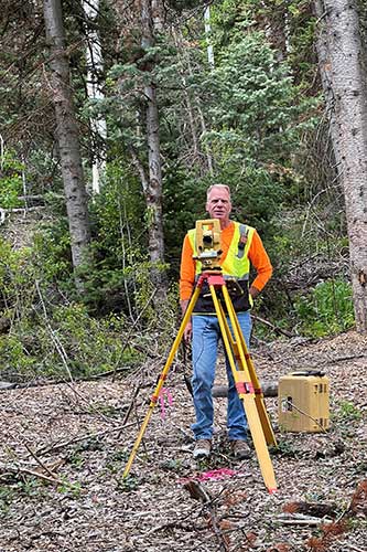 surveyor performing lot line measurements